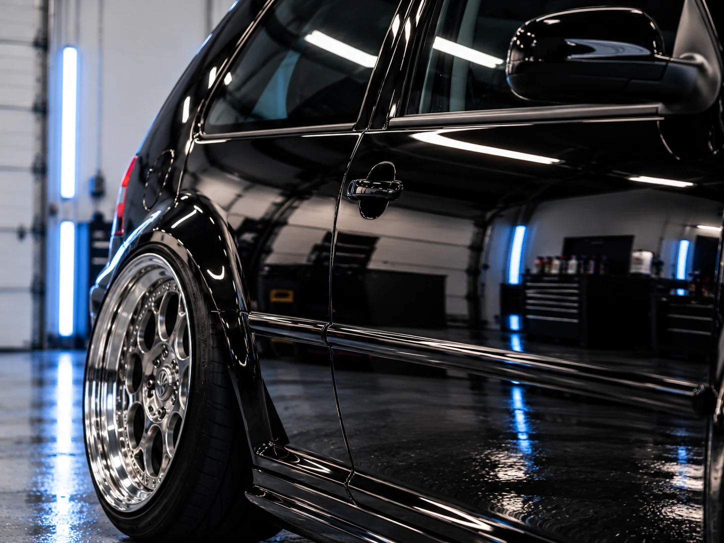 Close-up of glossy black side panels showing deep paint clarity